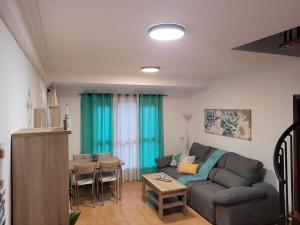 a living room with a couch and a table at PLAYA DEL NORTE VIVIENDA VACACIONAL in Gáldar +42 photos