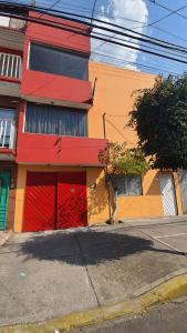 a building with a red door on a street at Hostal Don Diego in Mexico City