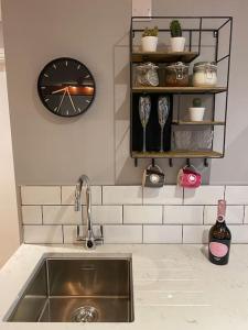 eine Küche mit einem Waschbecken und einer Uhr an der Wand in der Unterkunft The Retreat at La Sagesse in Windermere