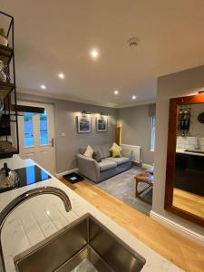 eine Küche und ein Wohnzimmer mit einem Sofa in einem Zimmer in der Unterkunft The Retreat at La Sagesse in Windermere
