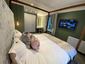 - une chambre avec un grand lit blanc et des oreillers dans l'établissement The Retreat at La Sagesse, à Windermere