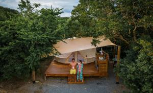 a man and a woman standing in front of a tent at Pitahaya Glamping in Cabo Rojo