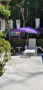 阿雷格里港的住宿－Morada das Flôres，紫色雨伞、椅子和桌子