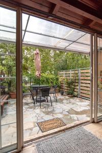 a patio with a table and a glass door at The Country ArtHS Retreat in Athens