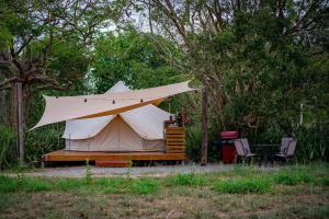 a large tent with a table and two chairs at Pitahaya Glamping in Cabo Rojo