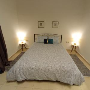 1 dormitorio con 1 cama grande y 2 lámparas en Aggeliki's guest house, en Nauplia