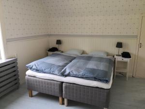 a bedroom with a large bed with two night stands at Gula huset, Lakene Ostgård in Lakene