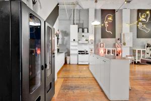 una cocina con armarios blancos y electrodomésticos blancos en St. Vincent Lofts en Los Ángeles