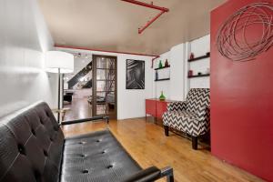 sala de estar con sofá y pared roja en St. Vincent Lofts en Los Ángeles