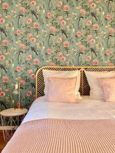 una camera da letto con un letto e carta da parati floreale di Le Carrousel - Appartement cosy centre Obernai a Obernai