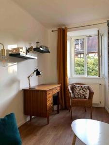 Pokój z biurkiem, krzesłem i oknem w obiekcie Le Carrousel - Appartement cosy centre Obernai w mieście Obernai