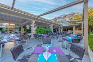 a patio with purple tables and chairs and a building at Belek Beach Resort Hotel in Belek