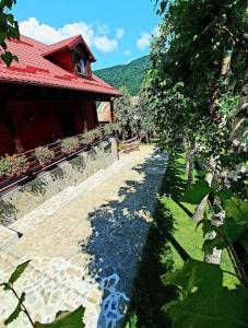 a path next to a building with a red roof at Old Mark's House Sinaia in Sinaia