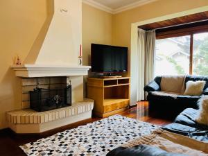 sala de estar con chimenea y TV en MRG- Colonial 2D - 200 mts da Rua Torta, en Gramado