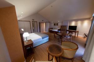 a hotel room with a bed and a table and chairs at Hotel Albatros in Ushuaia