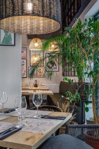 un restaurante con mesas de madera, sillas y plantas en Aparthotel Etna, en Kołobrzeg