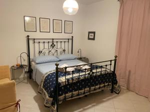 a bedroom with a black bed with blue pillows at Casa Giacobelli in Mola di Bari