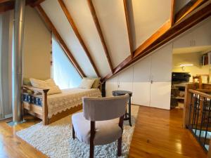 Schlafzimmer im Dachgeschoss mit einem Bett und einem Stuhl in der Unterkunft Casa Le Martial in Ushuaia