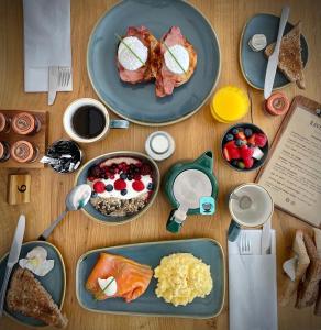 a wooden table with plates of breakfast food on it at Ravenscraig Guest House in Aviemore