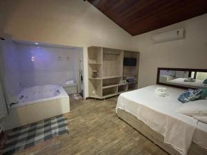 a bedroom with a large bed and a large mirror at Pousada Cipó Prata in Serra do Cipo