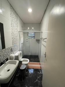 a bathroom with a shower and a toilet and a sink at Pousada Cipó Prata in Serra do Cipo