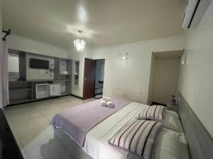 a bedroom with a large bed with two shoes on it at Pousada Cipó Prata in Serra do Cipo