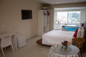 a bedroom with a bed and a table with a candle on it at Emirates Hotel & Suites in Santana do Livramento