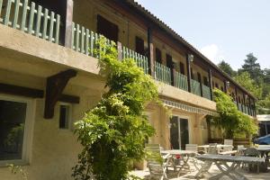 a building with tables and chairs in front of it at Gîte de Montagne Salle de Fête Thorenc in Andon