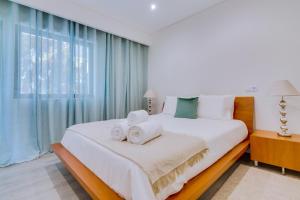 una camera da letto con un grande letto con asciugamani di Marina Star Guesthouse a Faro