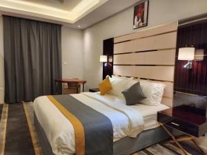 a bedroom with a large bed in a room at Rasis Furnished Apartments in Jeddah