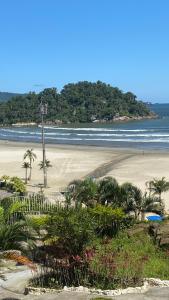 une plage de sable avec des palmiers et l'océan dans l'établissement Apartamento Frente ao Mar Santos II, à Santos