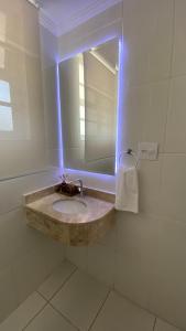 een badkamer met een wastafel en een spiegel bij Apartamento Frente ao Mar Santos II in Santos