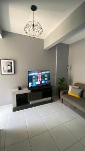 uma sala de estar com uma televisão de ecrã plano na parede em Apartamento Frente ao Mar Santos II em Santos