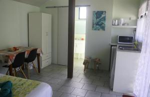 um quarto com uma cozinha e uma mesa com uma mesa; em Ranginuis Retreat em Arutanga