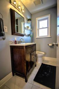 a bathroom with a sink and a toilet and a mirror at Charming Cozy Ravine Home Mins to Parks & Lake Entire House in Toronto