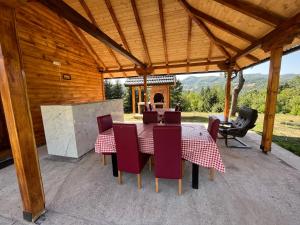 Vila Mana في إيفانييتسا: طاولة وكراسي يجلسون تحت سقف خشبي