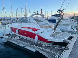 a red and white boat is docked at a dock at sea you later in Ponta Delgada