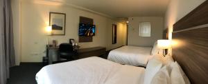 a hotel room with two beds and a desk at Holiday Inn Express Culiacan by IHG in Culiacán