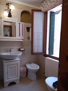 uma casa de banho com um lavatório e um WC em Casa Forner, Venezia em Veneza