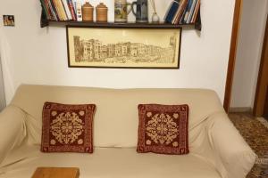 um sofá branco com duas almofadas em cima em Casa Forner, Venezia em Veneza