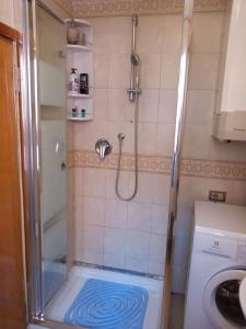 uma pequena casa de banho com um chuveiro e uma máquina de lavar roupa em Casa Forner, Venezia em Veneza