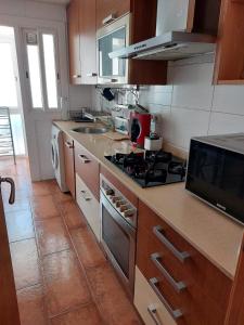 Apartamento tranquilo cerca de la Sagrada Familia في برشلونة: مطبخ مع موقد ومغسلة