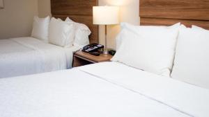 a hotel room with two beds and a phone on a table at Holiday Inn Express Culiacan by IHG in Culiacán