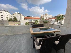 a patio with a table and chairs on a balcony at 360 Rooftop Apartment in Dabouq in Amman