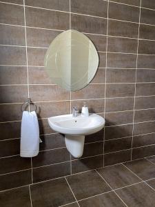 a bathroom with a sink and a mirror on a wall at 360 Rooftop Apartment in Dabouq in Amman