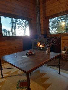 una mesa de madera en una habitación con chimenea en Veiga Mariña, en A Xesteira