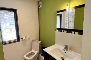 ein Badezimmer mit einem WC, einem Waschbecken und einem Spiegel in der Unterkunft Studio avec accès indépendant: Le 15 Bis in Violaines