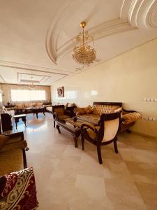 un grand salon avec des canapés et un lustre dans l'établissement Appart " Haut Standing Marοcain " 120m2 city center, à Tanger