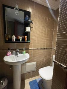 La salle de bains est pourvue d'un lavabo, de toilettes et d'un miroir. dans l'établissement Appart " Haut Standing Marοcain " 120m2 city center, à Tanger