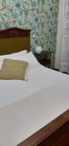 um quarto com uma cama branca e uma cabeceira em madeira em Cà Milene Bed and Breakfast em Castellinaldo